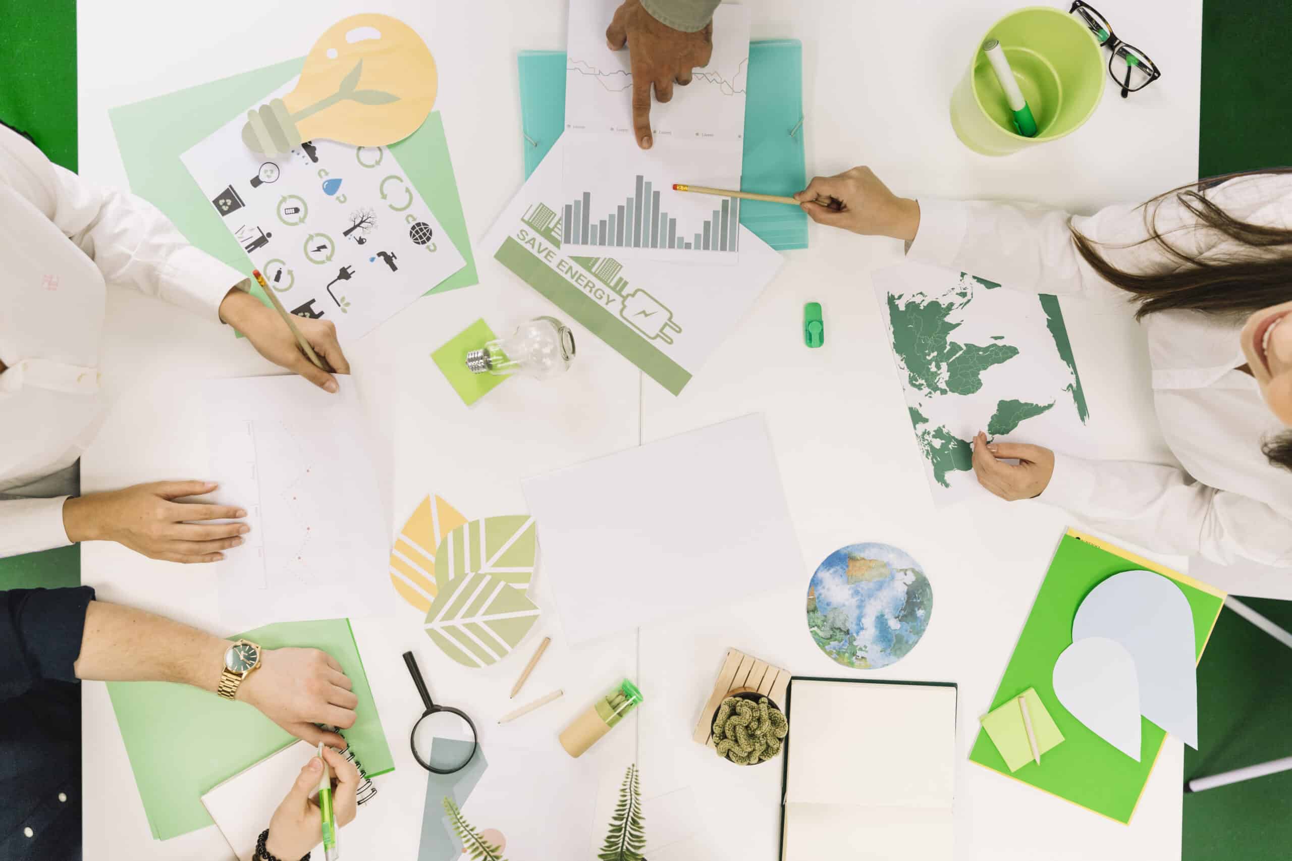 Empresários analisando gráficos e ícones de recursos naturais durante reunião sobre finanças verdes